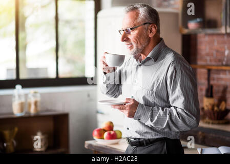 Leitenden Geschäftsmann mit Kaffee in der Küche zu Hause Stockfoto
