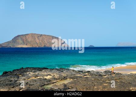 Lanzarote, Kanarische Inseln. Felsen und Strand von Playa de Las Conchas auf Isla Graciosa, Lanzarote. In Richtung Insel von Montana Clara Stockfoto