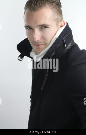 Gut aussehender Mann trug eine lange Jacke Stockfoto