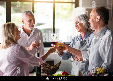 Familie jubeln mit Whiskey und Wein in der Küche Stockfoto