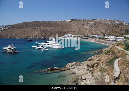 Psarou Beach Bay Insel Mykonos Griechenland mit blauem Himmel Meer und Yachten von Klippe mit Yachten Stockfoto