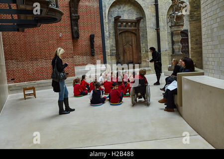 London, Gruppe der Schüler sitzen auf dem Boden hören die Führung in Victoria und Albert Museum ist die weltweit grösste Museum der Dekorativen Künste. Stockfoto