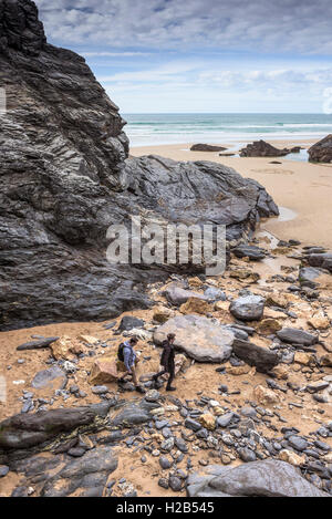 Touristen zu Fuß über die Felsen am Bedruthan Strand bei Ebbe.  Cornwall. Stockfoto