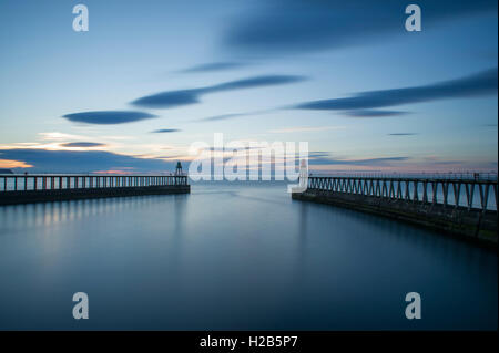 Eine Langzeitbelichtung Sommer Sonnenuntergang über dem Hafen von Whitby an der Nordküste Yorkshire Stockfoto