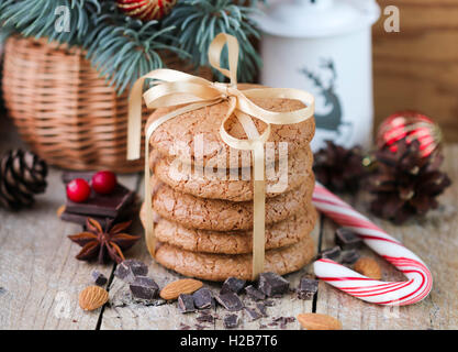 Gewürzte Kekse mit Mandeln. Weihnachtsgeschenke. Runde Kekse mit Band und Fichte Zweig in einem Korb auf dem Tisch gefesselt Stockfoto