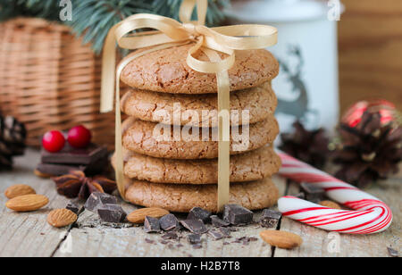 Gewürzte Kekse mit Mandeln. Weihnachtsgeschenke. Runde Kekse mit Band und Fichte Zweig in einem Korb auf dem Tisch gefesselt Stockfoto