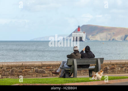 Paar auf einer Bank, die gerade die Irish Ferry von Fishguard ausgehen Stockfoto