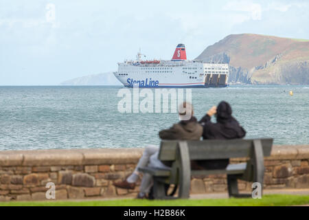 Paar auf einer Bank, die gerade die Irish Ferry von Fishguard ausgehen Stockfoto