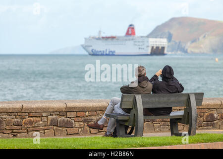 Paar auf einer Bank, die gerade die Irish Ferry von Fishguard ausgehen Stockfoto