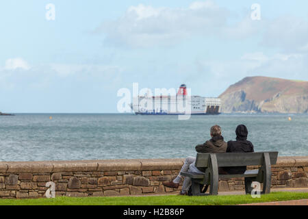 Paar auf einer Bank, die gerade die Irish Ferry von Fishguard ausgehen Stockfoto