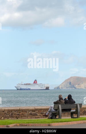 Paar auf einer Bank, die gerade die Irish Ferry von Fishguard ausgehen Stockfoto