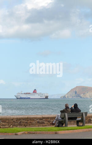 Paar auf einer Bank, die gerade die Irish Ferry von Fishguard ausgehen Stockfoto