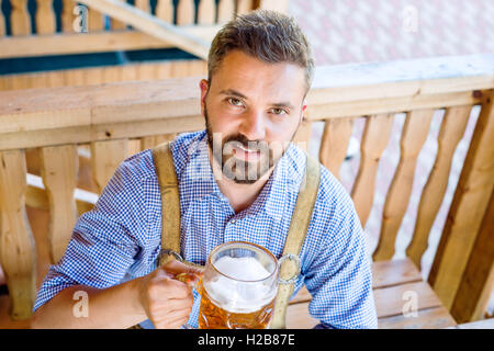 Mann in bayerischer Tracht mit Bier und Brezeln Stockfoto