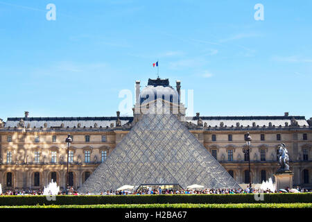 Touristen besuchen Museum Louvre in Paris. Berühmte Glaspyramide ist in der Ansicht. Stockfoto