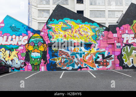 Wände mit Graffiti auf einem Parkplatz hinter der Custard Factory in Digbeth, Birmingham gemalt Stockfoto