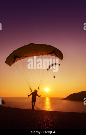 Sskydivers startbereit auf Hintergrund der Sonnenuntergang Himmel und Meer fliegen Stockfoto