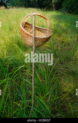 eine Nahaufnahme-Picknick-Korb auf einem Stab im Rasen, draußen mit grünen Hintergrund hängen Stockfoto