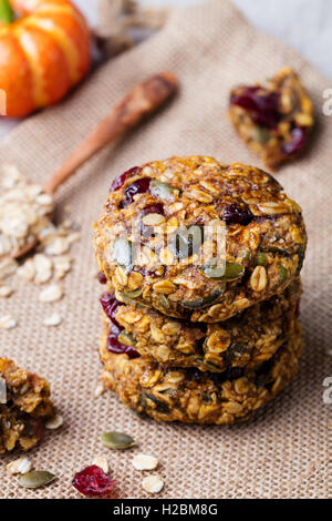 Hafer-Cookies mit Preiselbeeren und Ahorn Glasur auf rustikalen Textile Hintergrund. Stockfoto