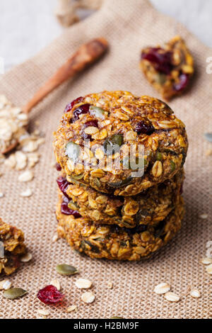 Hafer-Cookies mit Preiselbeeren und Ahorn Glasur auf rustikalen Textile Hintergrund. Stockfoto