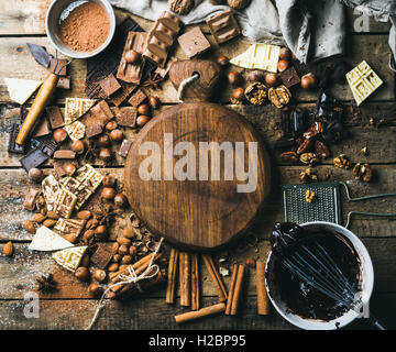 Schokolade, Nüssen, Kakao Pulver, Gewürze mit Holzbrett in Mitte Stockfoto