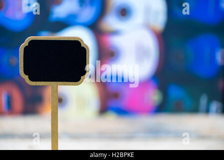 Hölzerne Mini Tafel Label über bunte traditionelle mexikanische Gitarren Hintergrund und Tabelle, Textfreiraum verfügbar Stockfoto