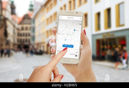 Finden Sie Drive-Smartphone-app in der Hand der Frau. Stadtplan, Trail, Fahrer und Auto auf Handy-Display. Stockfoto