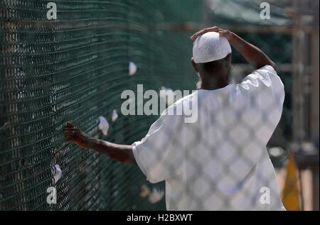 Ein Häftling aus dem Krieg gegen den Terror hält sich an ein Maschendrahtzaun stehen in einem Freizeit-Hof am gemeinsamen Aufgabe Guantanamo Lager IV 8. Juni 2010 in Guantanamo Bay auf Kuba. Stockfoto