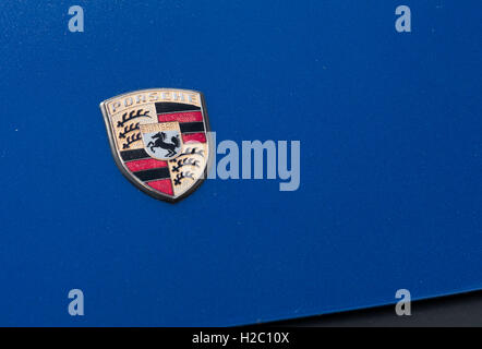 Porsche-Schild auf der Motorhaube blaues Auto Stockfoto