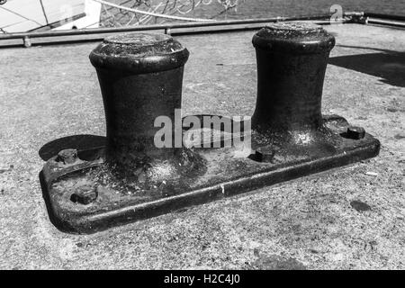 Großen Liegeplatz Poller montiert auf konkrete Pier im Hafen, schwarz / weiß Retro-Stil Foto Stockfoto