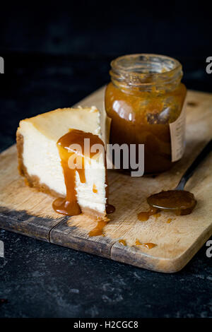 Käsekuchen mit Karamell-Sauce auf Schneidbrett aus Holz. Großaufnahme, selektiven Fokus Stockfoto