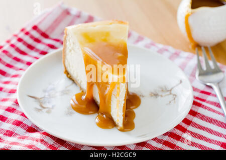 Käsekuchen mit Karamell-Sauce auf weißen Teller Stockfoto