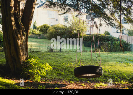 Am frühen Morgensonne auf einen Garten mit einer Reifen-Schaukel, Stockfoto