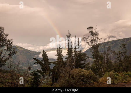 Sonnenuntergang Berglandschaft mit einem Regenbogen über Tungurahua Vulkan in Ecuador, Südamerika Stockfoto