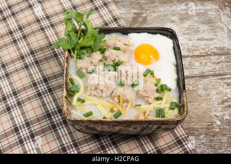 Reisbrei mit Schweinefleisch und weich gekochtes Ei Stockfoto