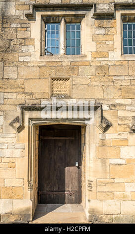 Eingang des alten Cotswold Steinhaus mit lateinischer Inschrift geschnitzt in das Mauerwerk Stockfoto