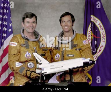 NASA Missionen STS-1 Columbia Space Shuttle Crew Mitglieder Astronauten John Young und Robert Crippen posieren für ein offizielles Porträt im Auswurf Flucht Anzüge mit einem kleinen Modell-Nachbau des Space Shuttles Columbia am Johnson Space Center 7. Mai 1979 in Houston, Texas. Die Columbia war der erste Orbiter von der NASA Space Shuttle-Programm ins Leben gerufen. Stockfoto