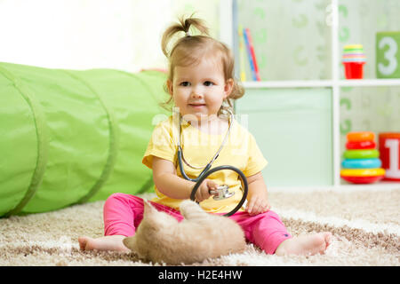 Kind Mädchen spielen Arzt mit einer Katze im Kindergarten Stockfoto