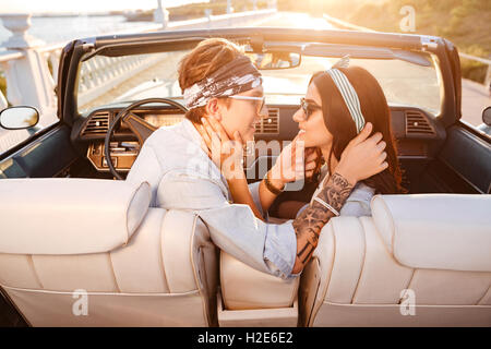 Schöne junge Brautpaar sitzen und küssen im Cabrio im Sommer Stockfoto