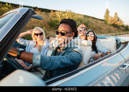 Gruppe von fröhlichen jungen Freunden Auto und lächelnd im Sommer Stockfoto