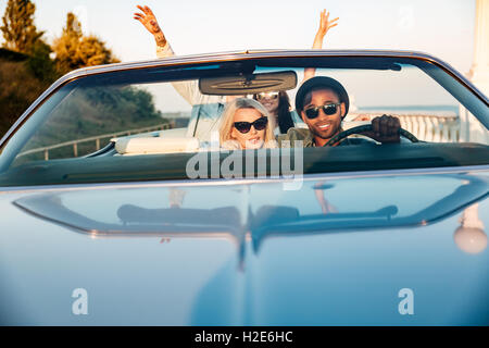 Zwei glückliche junge Paare mit erhobenen Händen im Auto Stockfoto