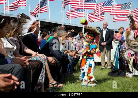 US-Präsident Barack Obama und First Lady Michelle Obama begrüßt einen jungen während der Kanonenkugel Flag Day Feier auf dem Gelände der Kanonenkugel Powwow während eines Besuchs in der Standing Rock Sioux Stammes Reservierung 13. Juni 2014 in Kanonenkugel, North Dakota. Stockfoto