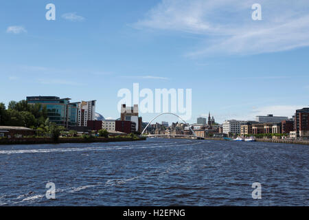 Den Fluss Tyne verläuft zwischen Gateshead und Newcastle in England. Die Gateshead Millennium Bridge verbindet die beiden Gemeinden. Stockfoto