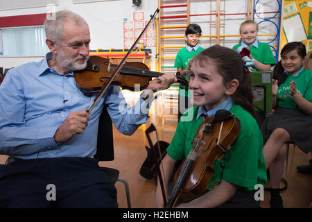 Labour-Chef Jeremy Corbyn erhält eine Geigenunterricht durch 10 jährige Jessica Kelly während eines Besuchs zu glauben Primary School in Liverpool, lernte er die Kinder, die Teilnahme an den In Harmony-Projekt, das stützt sich auf das Royal Liverpool Philharmonic Orchestra und hilft SchülerInnen und Schüler lernen, Musikinstrumente zu spielen. Stockfoto