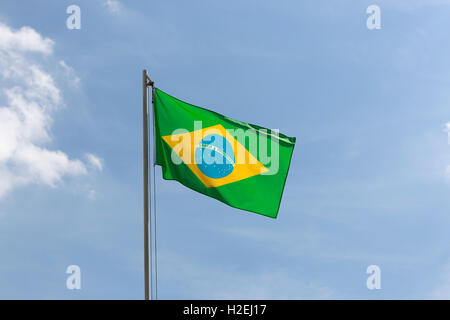 Nationalflagge von Brasilien auf einem Fahnenmast vor blauem Himmel Stockfoto