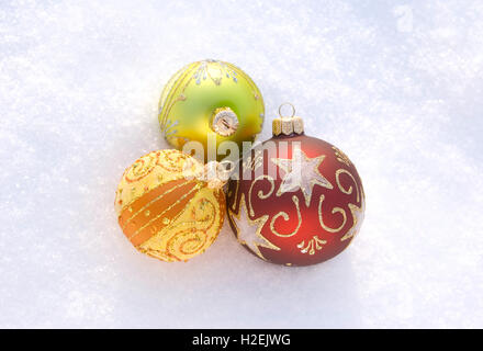 Drei schöne dekorative Kugeln auf einem weißen Schnee (Spielzeug kurz vor Weihnachten Geschenk Schnee Neujahr schmücken Kugeln) Stockfoto