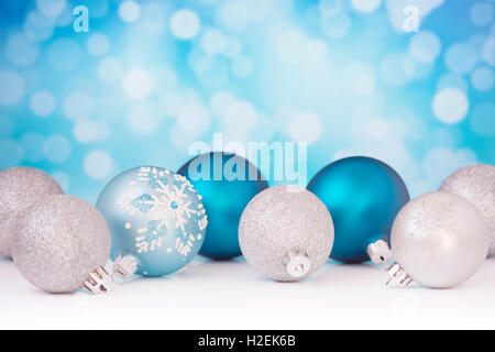Blau und Silber Weihnachtskugeln vor defokussierten lila und weißen Lichter. Stockfoto
