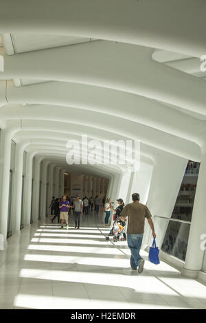 Besucher und Käufer in das Oculus Mall an das World Trade Center Fuß durch einen der Gänge mit Blick auf die zentrale Halle auf der einen Seite und Geschäfte auf der anderen. New York City. Stockfoto