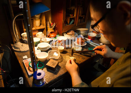 Peking, China. 27. Sep, 2016. Bai Yunze funktioniert auf eine zerbrochene Tasse in seinem Atelier in Peking, Hauptstadt von China, 27. September 2016. Bai Yunze und Li Fangyuan Klassenkameraden in der Universität und heiratete nach dem Studium. Da sie gemeinsame Interessen im traditionellen Handwerk der Lackkunst geteilt, begann sie ihr eigenes Studio und Lager in Peking, zu demonstrieren, sie schufen, Kunstwerke und Objekte, die sie gesammelt. Sie wollen die Lackkunst im täglichen Leben der Menschen mehr anerkannte machen. © Weng Xinyang/Xinhua/Alamy Live-Nachrichten Stockfoto