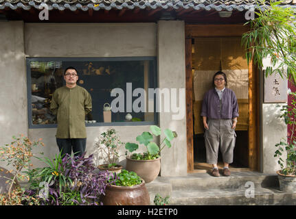 Peking, China. 27. Sep, 2016. Bai Yunze (L) und seine Frau Li Fangyuan posieren für Foto vor ihrem Laden "Tu Qi" in Jianchang Hutong in Peking, Hauptstadt von China, 27. September 2016. Bai Yunze und Li Fangyuan Klassenkameraden in der Universität und heiratete nach dem Studium. Da sie gemeinsame Interessen im traditionellen Handwerk der Lackkunst geteilt, begann sie ihr eigenes Studio und Lager in Peking, zu demonstrieren, sie schufen, Kunstwerke und Objekte, die sie gesammelt. Sie wollen die Lackkunst im täglichen Leben der Menschen mehr anerkannte machen. © Weng Xinyang/Xinhua/Alamy Live-Nachrichten Stockfoto