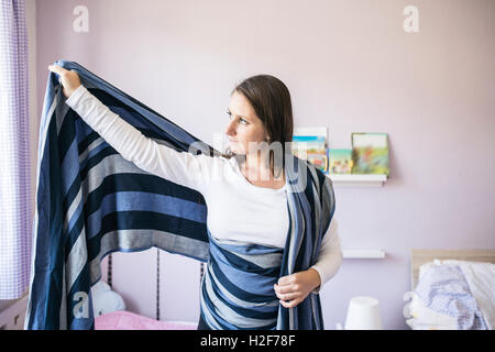 Schöne junge Mutter Verpackung Tragetuch für Ihr baby Stockfoto